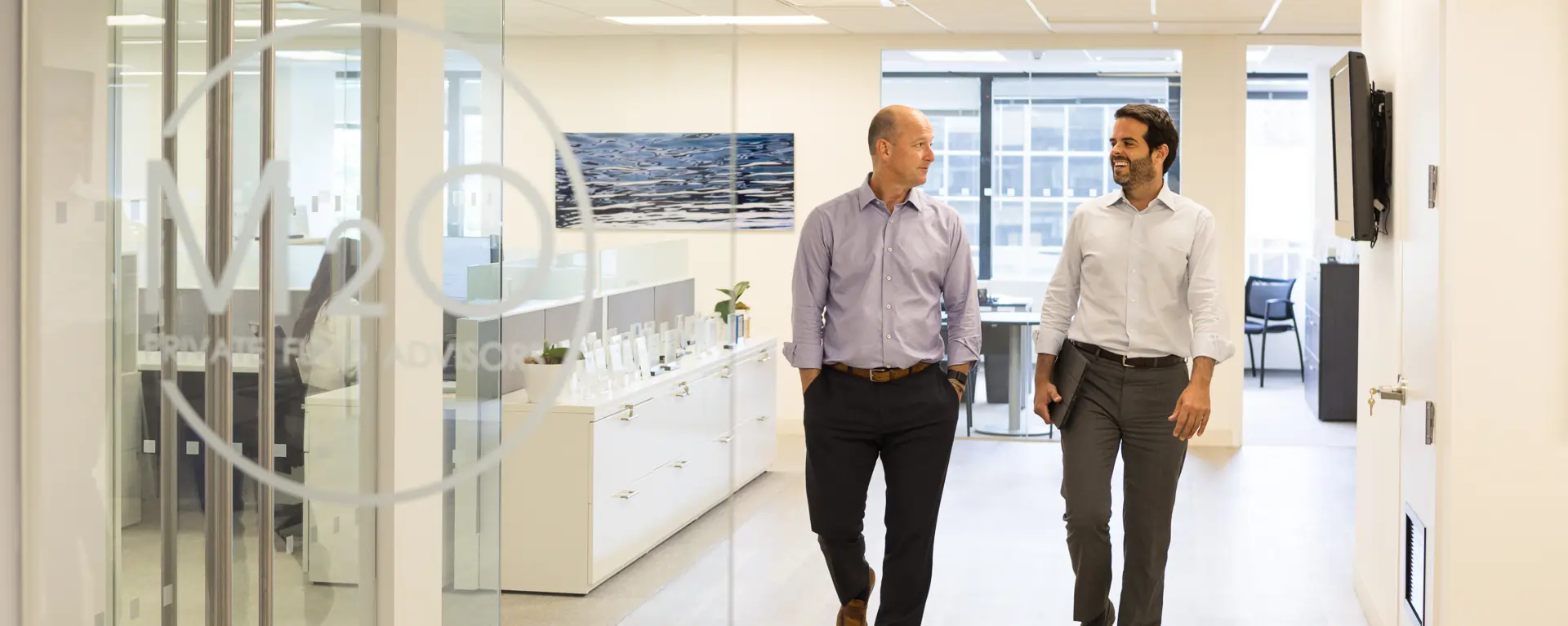 M2O staff walking and talking in office hallway